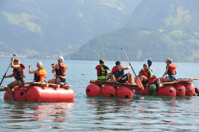 Teilnehmerinnen und Teilnehmer des Ferienpasses Nidwalden auf ihren selbst gebauten Flössen. 