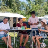 Eigentlich ist es für das schnelle Spiel fast zu heiss: Philipp Bucher, Karin Maienfisch und die Kinder Andri (12) und Ladina (11) spielen «Ligretto» (von links). (Bild: Maria Schmid (Unterägeri, 19. Juli 2022))
