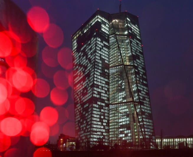Die Zentralbank reagiert, zu hoch ist die Inflation, zu hoch sind die geld- und wirtschaftspolitischen Risiken. Bild: Eine rote Ampel an der Europäischen Zentralbank (EZB) in Frankfurt und Regentropfen auf dem Kameraobjektiv erzeugen kreisförmige Reflexionen.