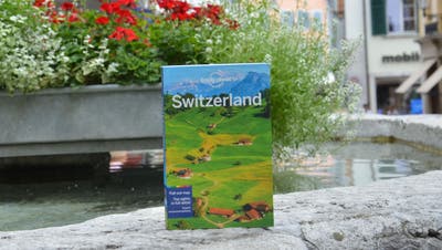 Der Reiseführer «Lonely Planet Switzerland» auf dem Gerechtigkeitsbrunnen in Solothurn. (Fabio Vonarburg)