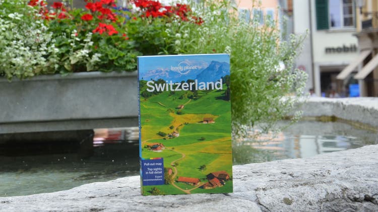 Der Reiseführer «Lonely Planet Switzerland» auf dem Gerechtigkeitsbrunnen in Solothurn. (Fabio Vonarburg)