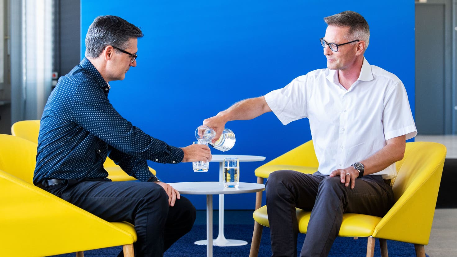 Kantonschemiker Silvio Arpagaus (links) lässt sich von Patrik Rust, Vorsitzender der EWL-Geschäftsleitung reines Wasser einschenken. (Bild: Eveline Beerkircher (Luzern, 9. August 2022))