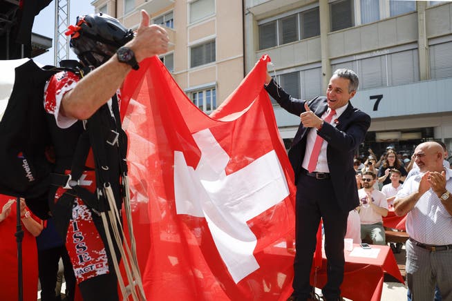 Bundespräsident Ignazio Cassis, rechts, posiert mit einer Schweizer Fahne. Die Schweiz hat eine lange historische Tradition als Schutzmacht. Ob sie nun die Interessen der Ukraine in Moskau vertreten darf, steht in den Sternen. 