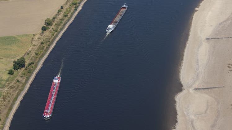 Nur halbvoll beladene Schiffe fahren bei niedrigem Wasserstand in der Fahrrinne des Rheins bei Köln. Die anhaltende Trockenheit lässt den Pegel des Rheins immer weiter sinken. (Keystone)