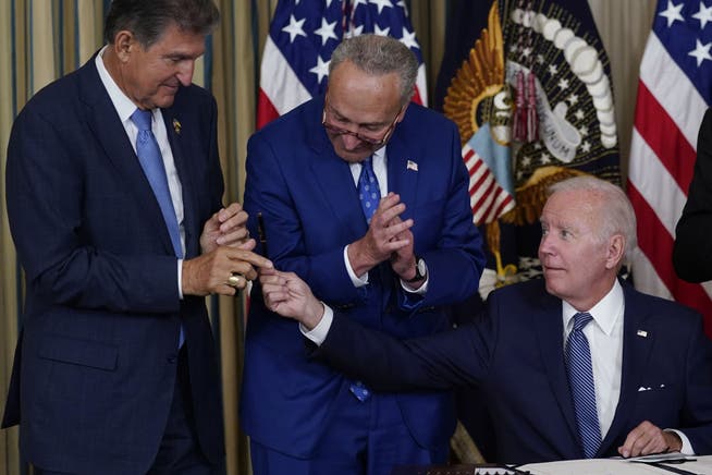 Der amerikanische Präsident Joe Biden (rechts) am Dienstag im Weissen Haus. Das Gesetzespaket, das er mit seiner Unterschrift in Kraft setzte, beruht auf einem Kompromiss, den die beiden Senatoren Joe Manchin (links) und Chuck Schumer ausarbeiteten.