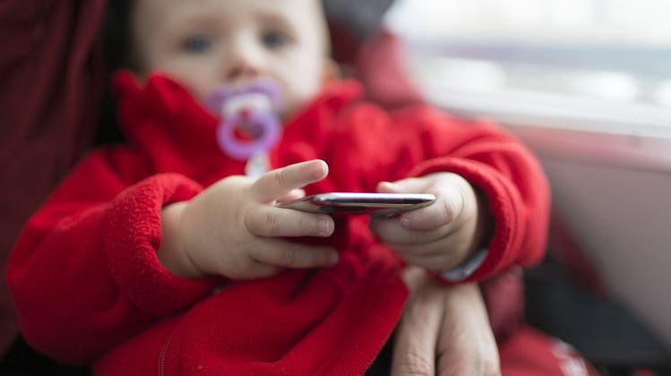 Handys oder Tablets sind beliebte sowie umstrittene Mittel zur Ruhigstellung von Kindern. (Bild: Gaetan Bally/Keystone)