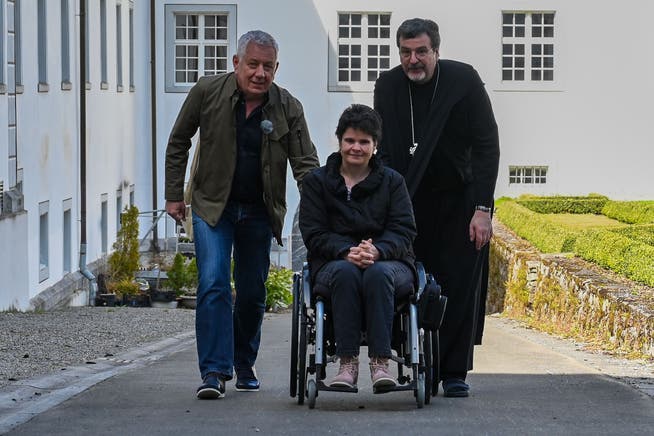 Mit vereinten Kräften schieben Abt Christian Meyer und «Happy Day»-Moderator Röbi Koller die im Rollstuhl sitzende Theres Hurschler die Rampe im Klostergarten zur nächsten Überraschung hoch.