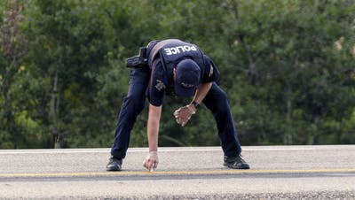 Ein kanadischer Polizist im Einsatz – die Sicherheitskräfte fahndeten drei Tage lang nach den Tätern. (Keystone)
