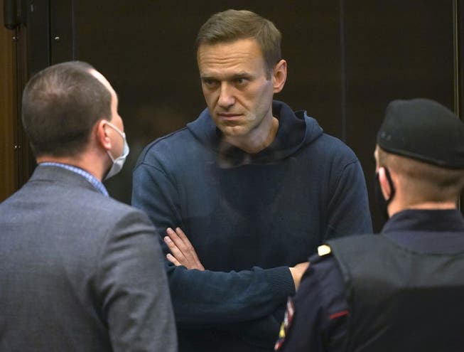 Alexey Nawalny spricht mit einem seiner Anwälte, während einer Anhörung zu einem Antrag der russischen Strafvollzugsbehörde, die zur Bewährung ausgesetzte Strafe Navalnys aus der strafrechtlichen Verurteilung von 2014 in eine echte Haftstrafe im Moskauer Stadtrat umzuwandeln (Archivbild Februar 2021). 