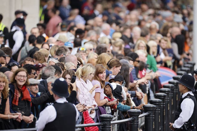 Die Zuschauerbereiche entlang der Route des Trauerzugs für Queen Elizabeth II. sind komplett mit Menschen gefüllt.