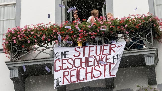 Im Geldregen: Die Juso protestierten am Rande der Landratssitzung gegen «Steuergeschenke für die Reichsten.»