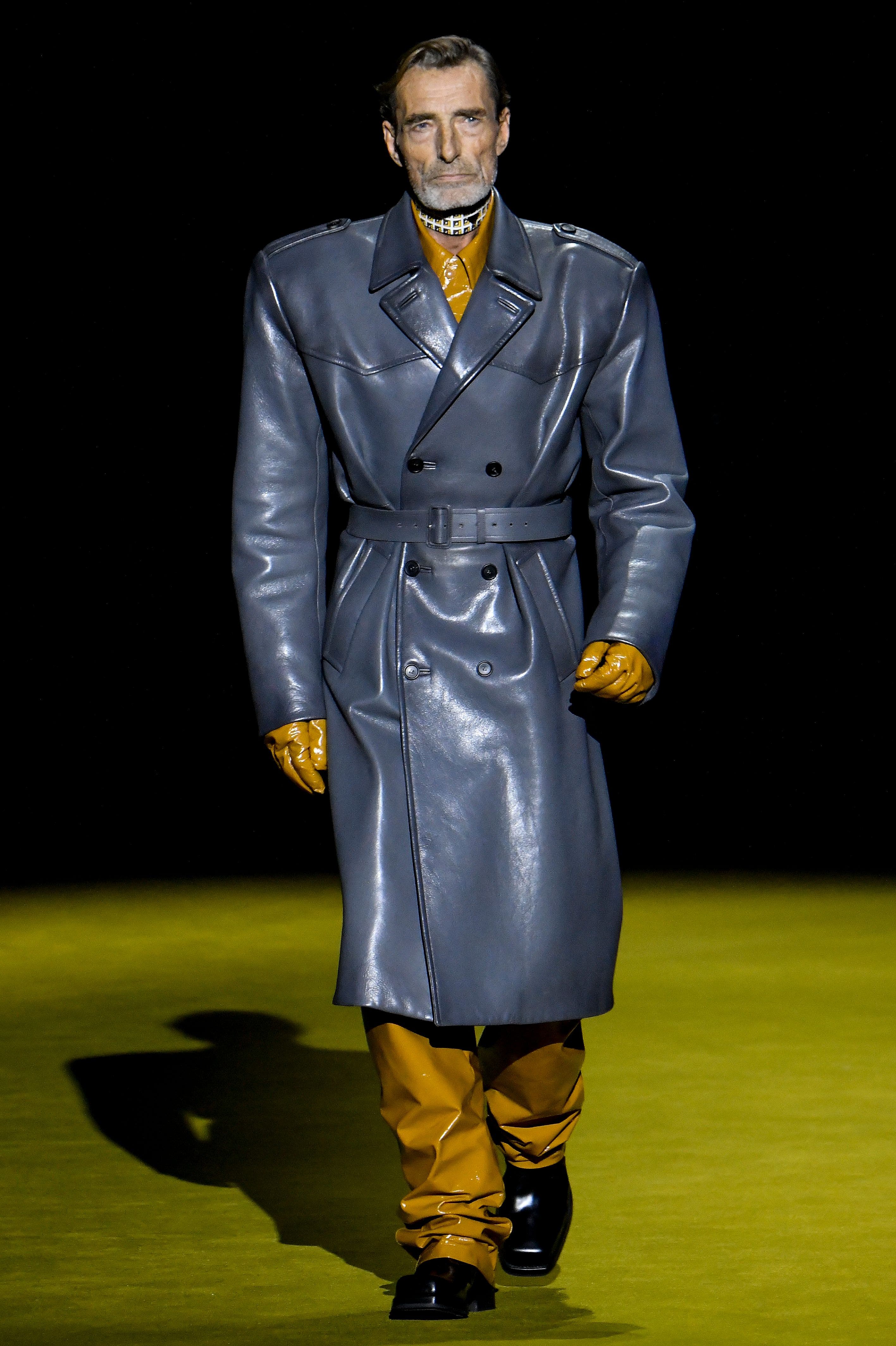 Prada interpretiert den Trenchcoat für Herren in boxiger Form und maus- grauem Leder.