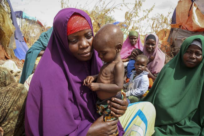 A mother holds her malnourished child in a suburb of Mogadishu, the capital of Somalia. Millions of people are at risk of starvation in the long-standing civil war country.
