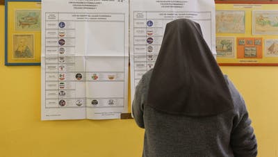 Eine Nonne studiert in einem Wahllokal in Rom die Wahlliste. (Giuseppe Lami / EPA)