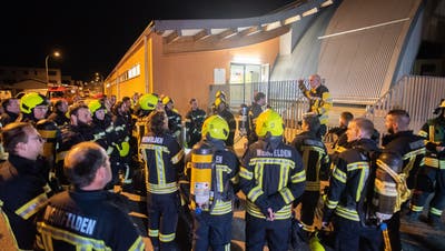 Einsatzleiter Stefan Frei erklärt den Weinfelder Feuerwehrleuten, weshalb er sie in so grosser Anzahl zum Einsatz bei der Eishalle aufgeboten hat. (Bild: Mario Testa)