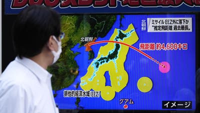 Ein Passant in Tokio informiert sich über die aus Nordkorea abgefeuerte Rakete. (Keystone)
