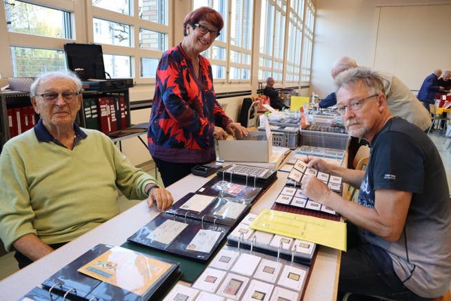 Sorel und Vera Fliss zeigen einem Besucher alte Briefmarken.