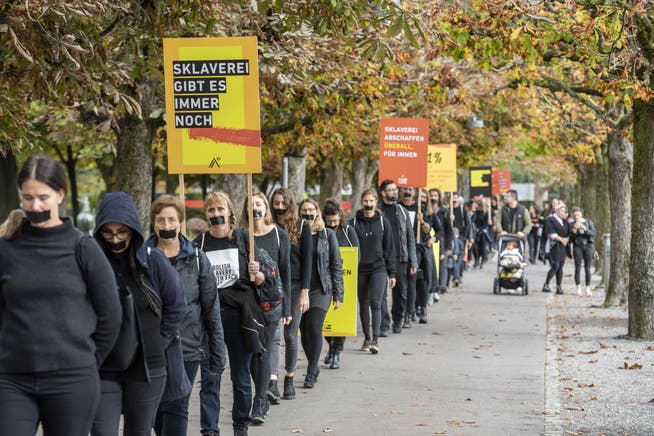 Demonstranten marschieren beim walk for Freedom in einer Einerkolonne gegen Menschenhandel und moderne Sklaverei bei einer Aktion am Samstag, 15. Oktober 2022 in Luzern. 