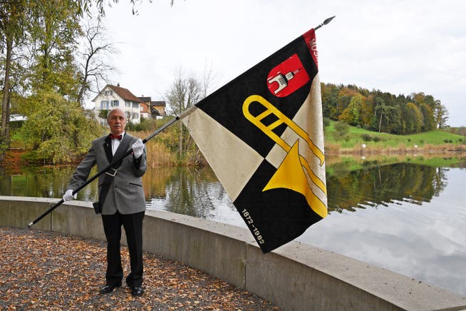 Fähnrich Herbert Rusch steht mit der alten Vereinsfahne beim Weiherdamm in Hauptwil.