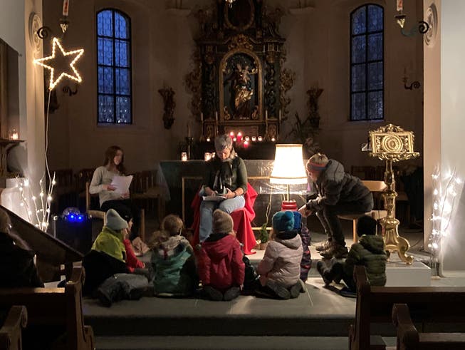 Kinder lauschen einer Weihnachtsgeschichte in der Kirche.