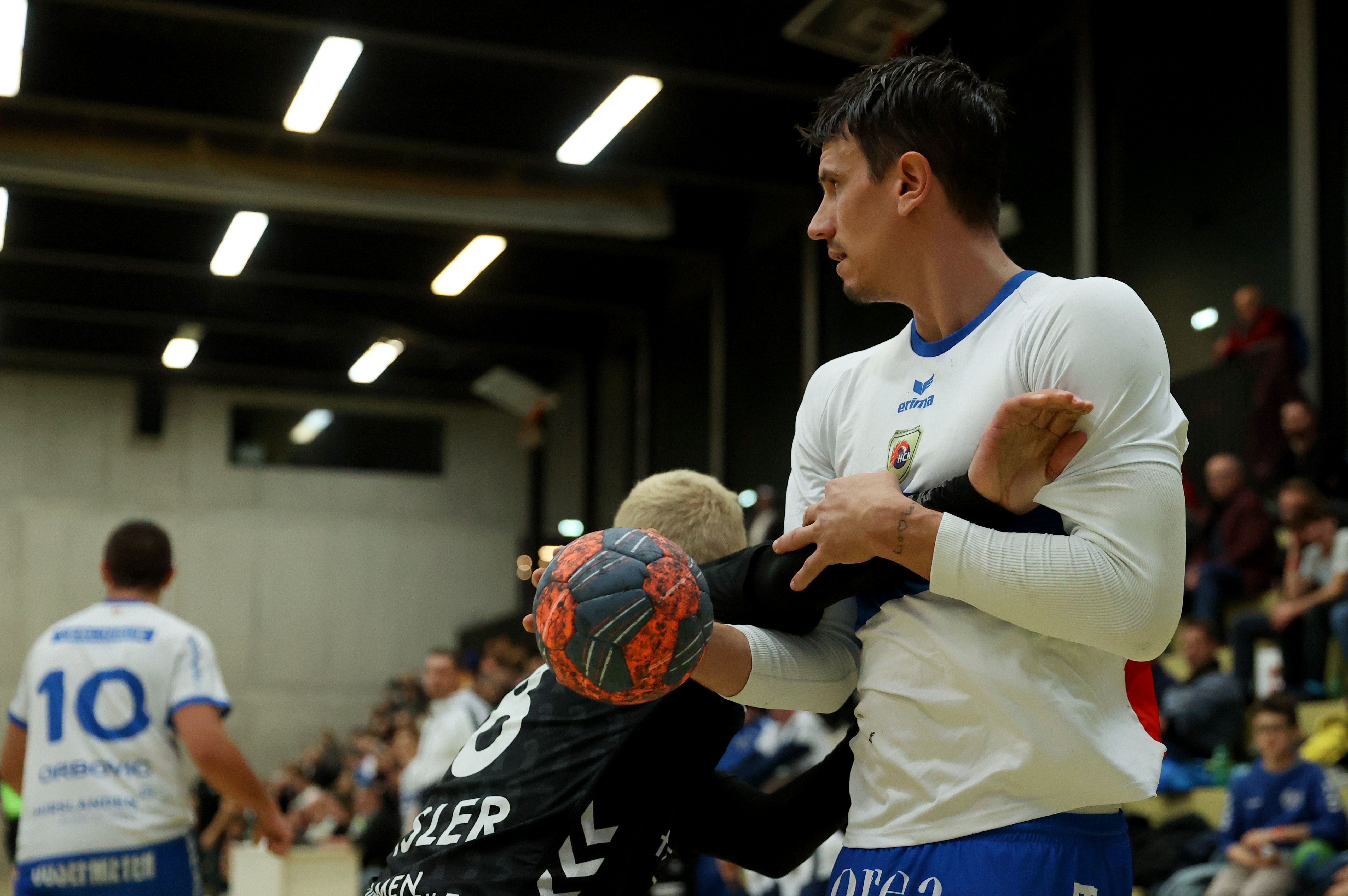 Maurus Basler (schwarzes Trikot) versucht den Handballstar Andy Schmid zu stoppen.