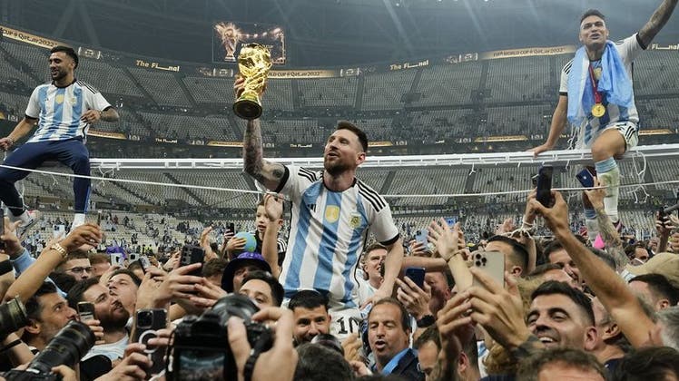 Endlich vereint: Lionel Messi und der WM-Pokal. (AP)