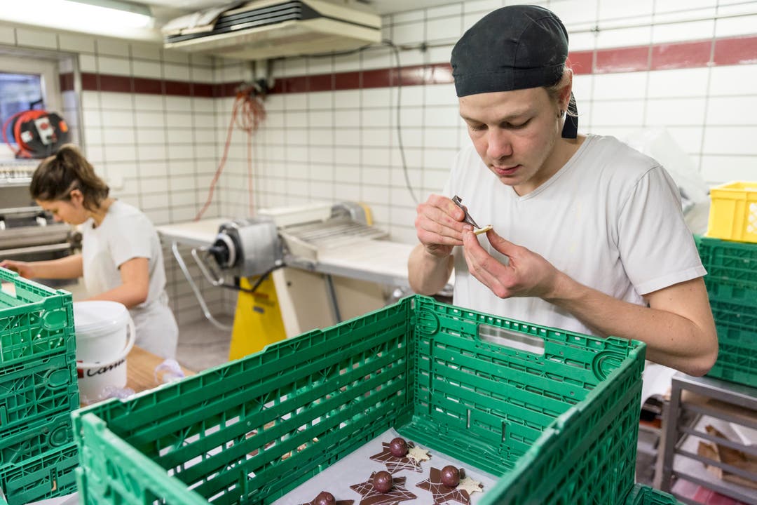 Dario Burkhalter, Beck-Konditor, und Julia Schoch bereiten Dekorationen aus Schokolade für Torten vor. 