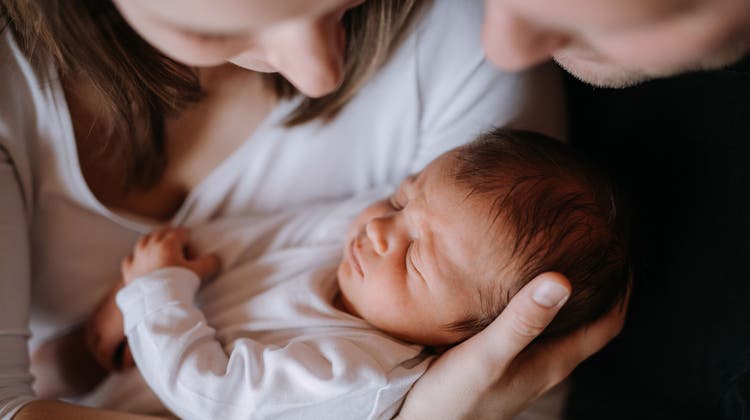 Fortpflanzungsmedizin ist politisch umstritten: Ein Paar mit seinem neugeborenen Kind. (Halfpoint Images / Moment RF)