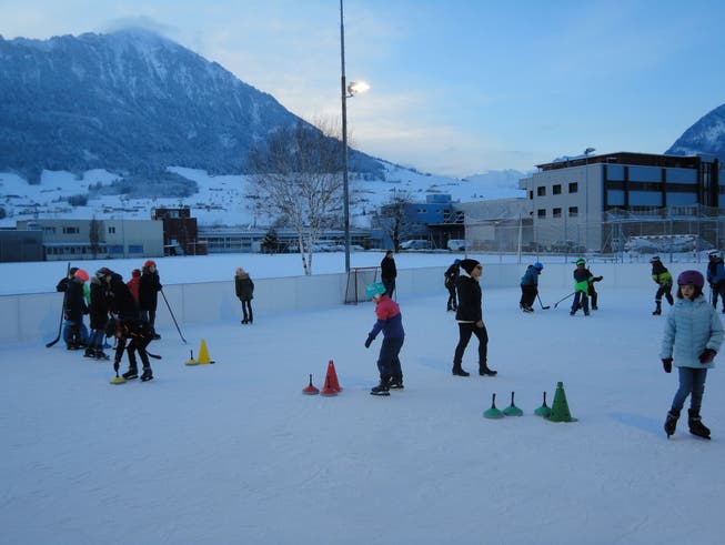 Die Schulklasse trifft sich zum Eisstockschiessen und Eishockey bei herrlicher Winterlandschaft.