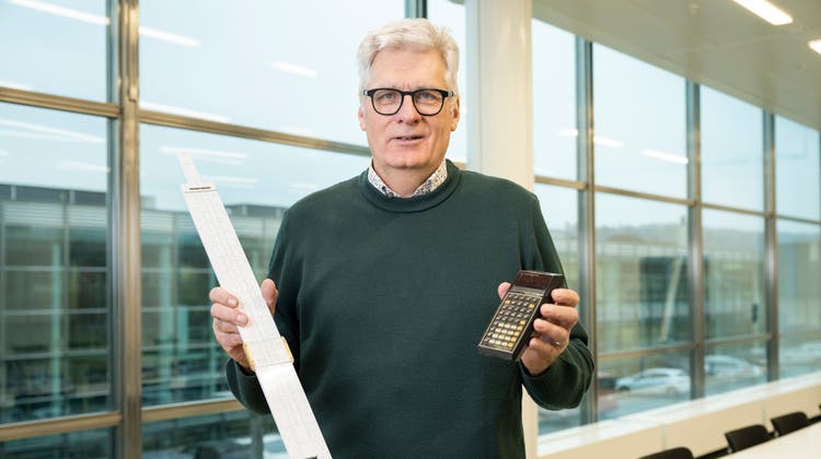 Daniel Thommen hält einen Rechenschieber, mit dem man früher mit Hilfe von Logarithmen rechnete, und einen der ersten wissenschaftlichen Taschenrechner von TI (Texas Instruments) in den Händen. (Alex Spichale)