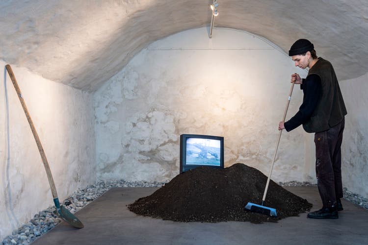 Installation mit Erde, Video und Soundcollage. Neben ihm Rinaldo Wälti auf dem Besen.