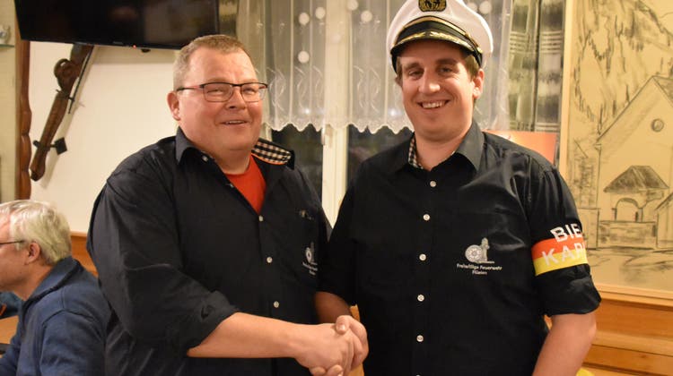 Mit einer Kapitänmütze wechselte das Präsidium der Freiwilligen Feuerwehr Flüelen von Lük Walker (links) zu Samuel Käslin. (Georg Epp / Urner Zeitung)