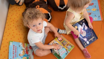 Zwei Kinder beschäftigen sich in einer Kita mit Kinderbüchern. (Gaëtan Bally / Keystone)