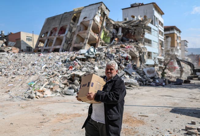 Ein Mann trägt eine Box mit Hilfsgütern in Hatay im Süden der Türkei. 