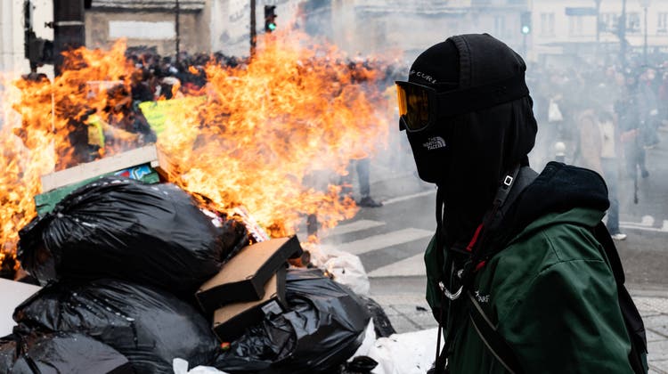 Ein Vertreter des Schwarzen Blocks am Donnerstag beim Zündeln in Paris. (Bild: Samuel Boivin / Imago)