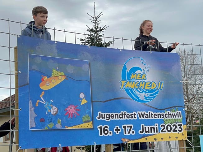 Die Schüler Nils und Andrine enthüllen das Logo für das Jugendfest Waltenschwil 2023.