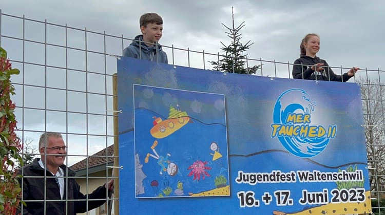 Die Schüler Nils und Andrine enthüllen das Logo für das Jugendfest Waltenschwil 2023. (Bild: Pascal Bruhin)