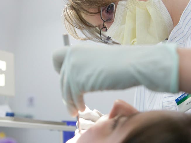Eine Dentalhygienikerin behandelt eine Patientin.