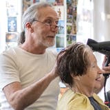 Die letzte Kundin des Salons Philipp, Marlis Arnet, lässt sich eine elegante Frisur schneiden. Coiffeur Philipp Christen und seine Frau Barbara gehen in Pension. (Bild: Maria Schmid (Zug, 31. 3. 2023))