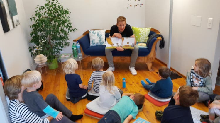 Gebannt hören die Kinder in der Bibliothek Speicher einem vorlesenden Vater zu. (Bild: ck)