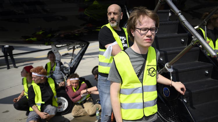Klimaaktivisten ketten sich bei einer Verkaufsmesse am Flughafen Genf an einen Privatjet (23. Mai 2023). (Bild: Laurent Gillieron / EPA)