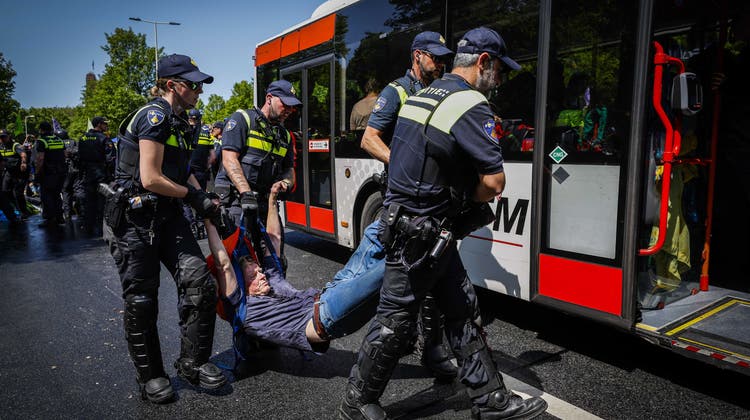 Polizisten tragen Demonstrierende weg und verfrachten sie in Busse. (Bild: Sem Van Der Wal / EPA)