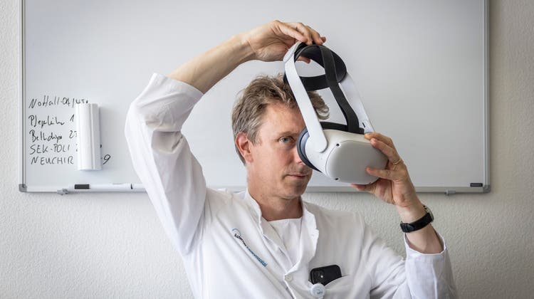 Christian Kamm, Leiter des MS-Zentrums im Luzerner Kantonsspital, setzt eine Virtual-Reality-Brille auf. (Bild: Patrick Hürlimann, (Luzern, 26. 5. 2023))