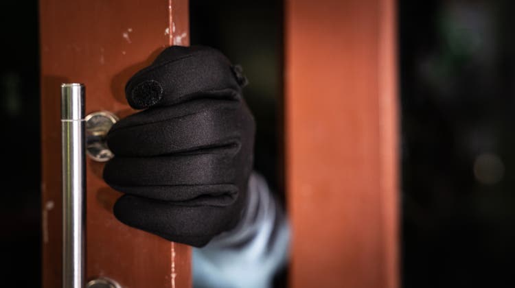 Eine Person mit Handschuhen öffnet eine Türe. (Bild: Getty Images)