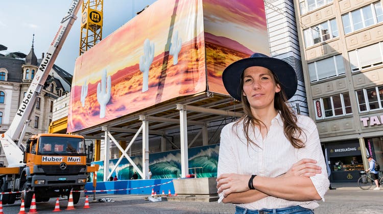 Claudia Comte vor ihrer gedruckten Installation auf der Globusfassade. Das Kunstwerk trägt den Namen «Waves, Cacti and Sunsets». (Bild: Nicole Nars-Zimmer)