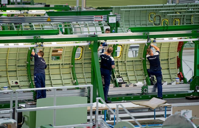 Mitarbeiter der Pilatus-Flugzeugwerke beim Verarbeiten von Flugzeugelementen. 