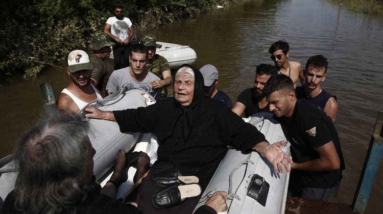 Freiwillige mit Booten helfen den von den Überschwemmungen betroffenen Menschen. (Bild: Yannis Kolesidis / EPA)
