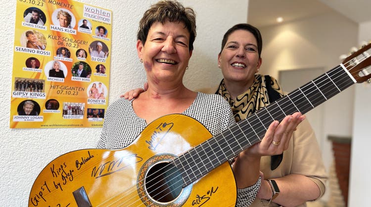 Anita Amsler (links) und Angi Simoniello präsentieren die signierte Gitarre, die sie verlosen. (Bild: Nathalie Wolgensinger)