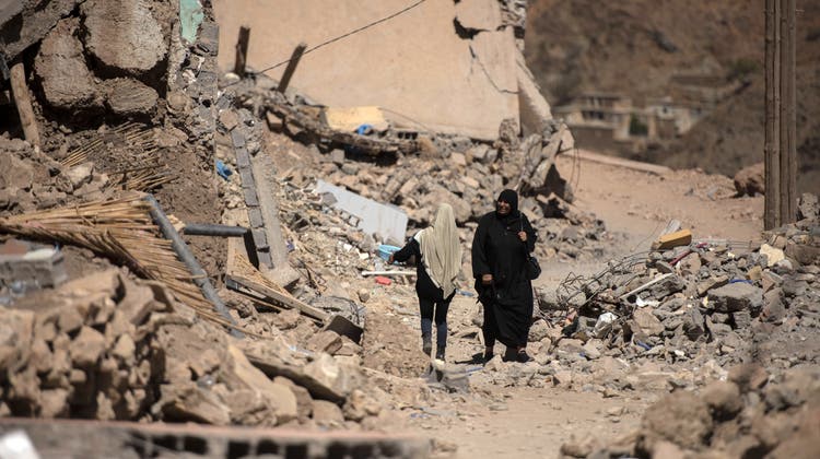 epaselect epa10872132 A woman walks through rubble in earthquake-hit village of Emi-Ntala, Marrakech, Morocco, 20 September 2023. A 6.8-magnitude earthquake struck central Morocco late September 08, killing nearly 3,000 people and damaging buildings from villages and towns in the Atlas Mountains to Marrakech, according to a report issued by the country's Ministry of Interior.  EPA/JALAL MORCHIDI (Jalal Morchidi / EPA)