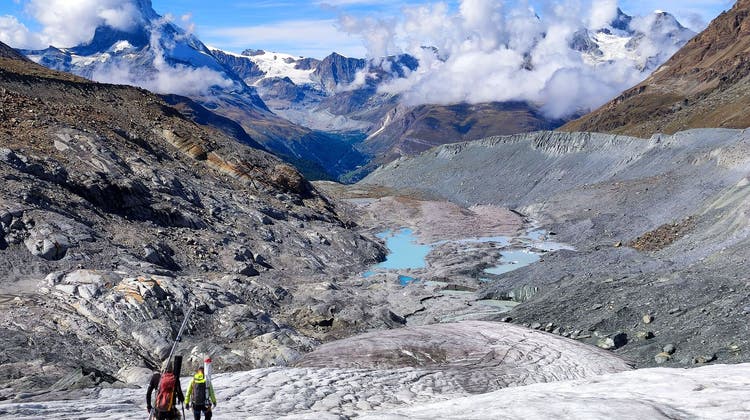 Glaziologen steigen über die zerfallende Zunge des Findelgletschers ab. Noch vor einem Jahrzehnt waren die leuchtend blauen Gletscherseen von Dutzenden Metern Eis bedeckt. (Bild: Matthias Huss)